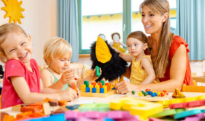Kindergartener woman with children playing a game