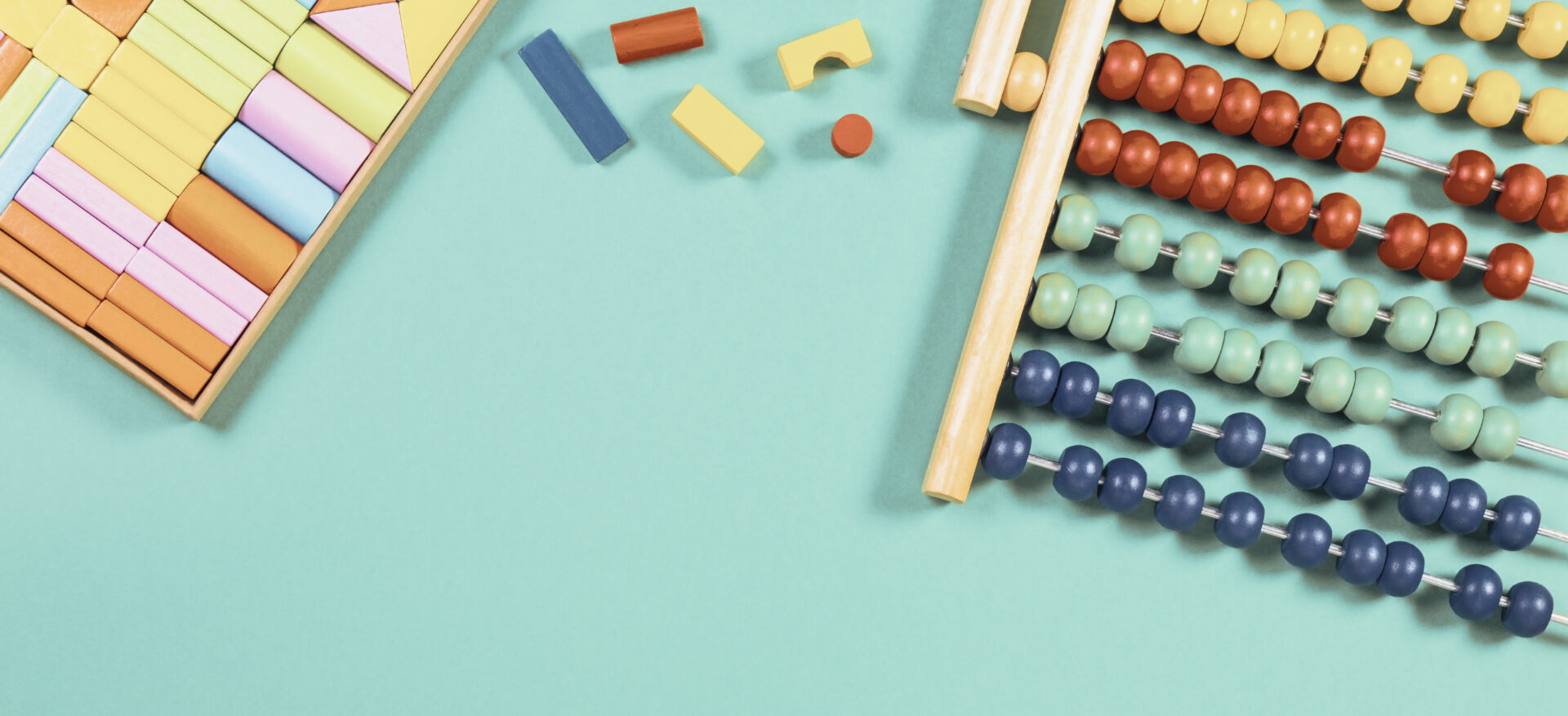Baby kids toys background. Abacus and wooden cubes on light blue background. Top view.
